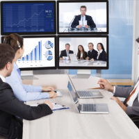 Businesspeople Sitting In A Conference Room Looking At Computer Screen